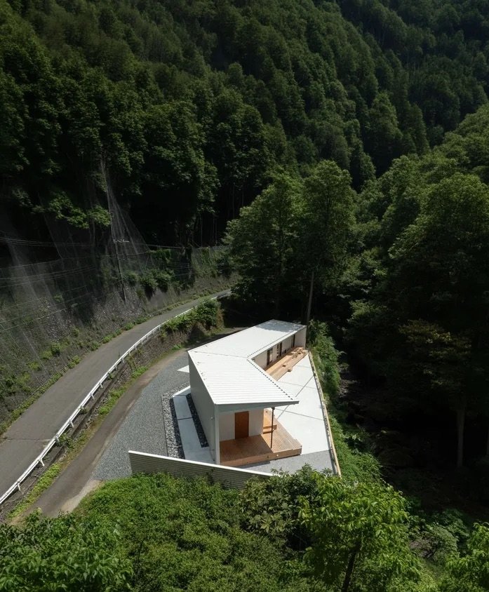 山道沿いに建つ HOUSE IN UNAZAWA を上空から望む